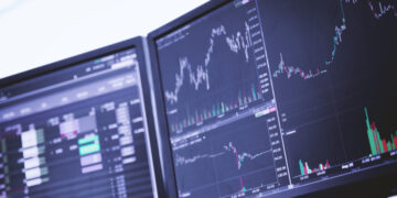 Dois monitores com índices da Bolsa de Valores.