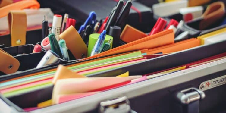 Vários materiais escolares, como canetas, post-its e páginas coloridas.