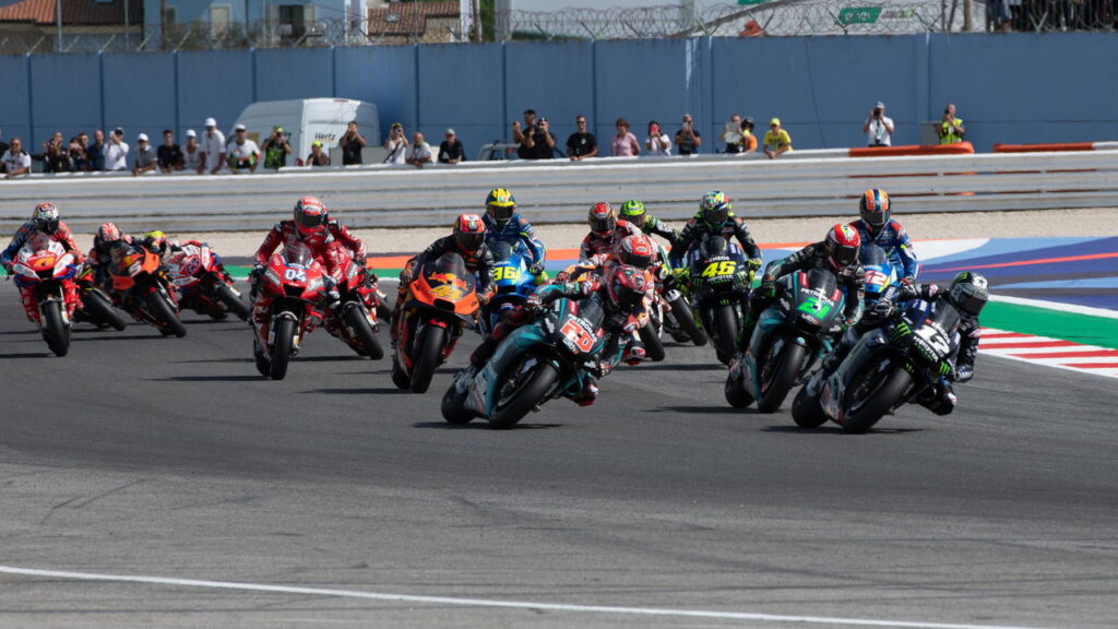 Artigo examinando o interesse de Lewis Hamilton na MotoGP e suas implicações potenciais no esporte a motor, além de seus movimentos paralelos na Fórmula 1.