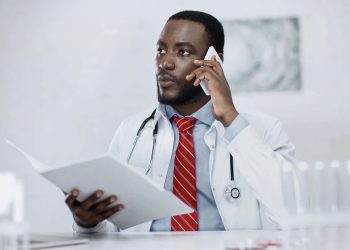 Médico usando o telefone - Créditos: depositphotos.com / AntonLozovoy