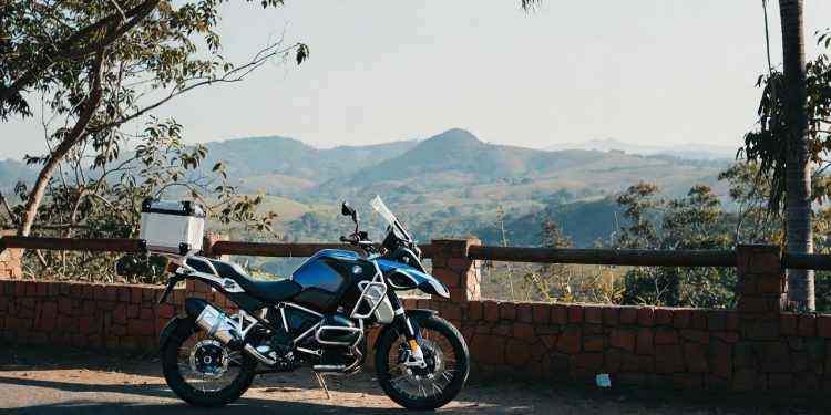 Motocicleta BMW R 1300 GS com farol em X rodando em estrada sinuosa ao entardecer