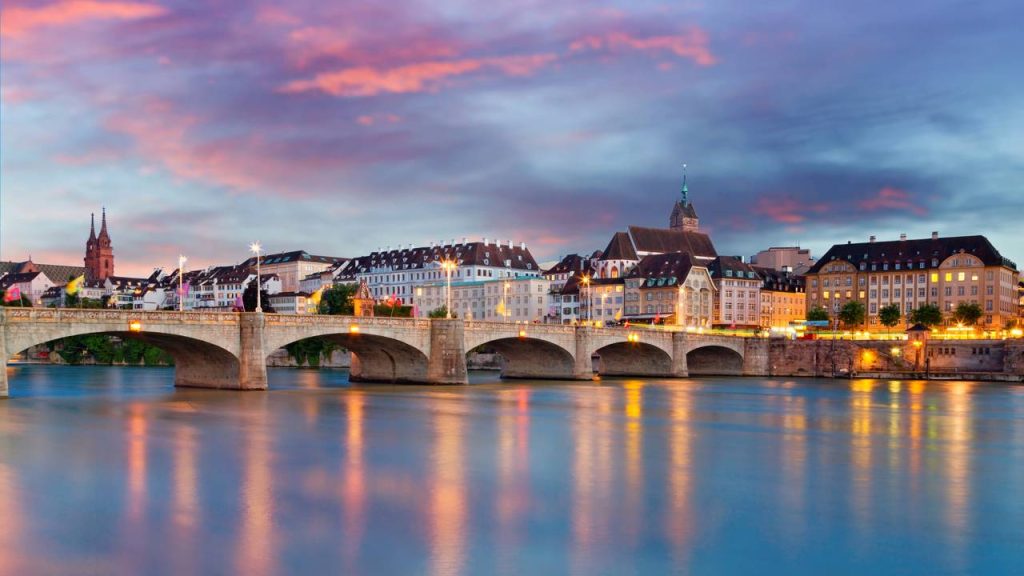 Uma vista aérea cinematográfica que mostra o contraste fascinante entre moradias de tijolos e lonas azuis à beira de um rio límpido