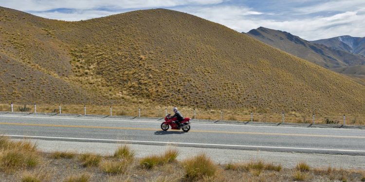 A rodovia de montanha que atinge 971 metros de altitude através de colinas douradas de capim, sendo a passagem estatal mais alta da Ilha Sul