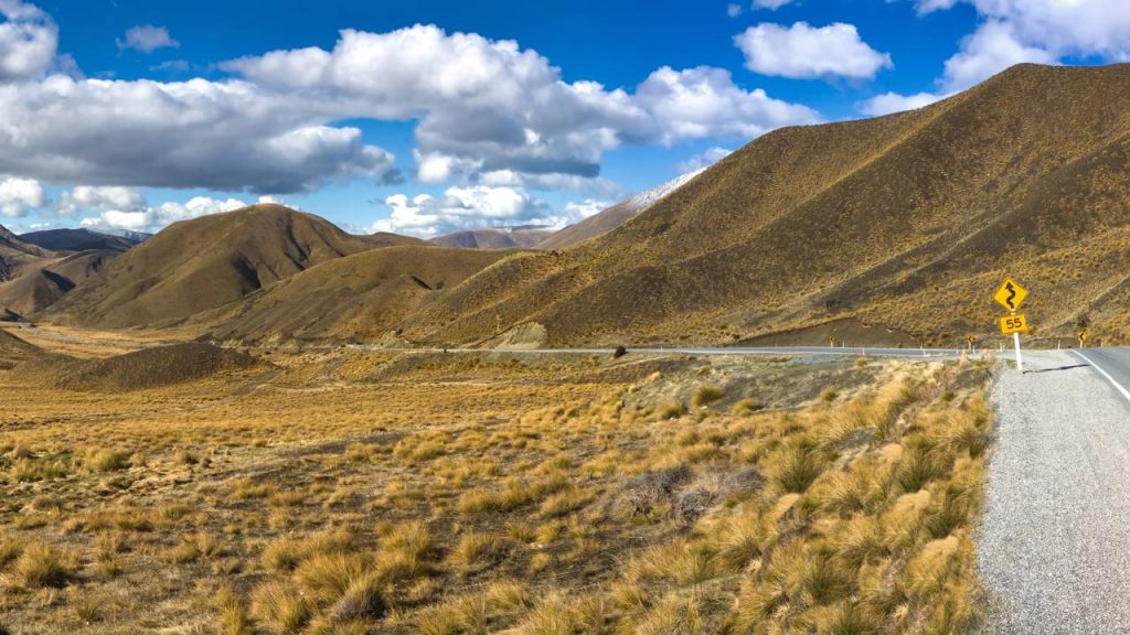Estrada na Nova Zelândia atinge 971 m de altitude; com suas colinas douradas e curvas suaves, a Lindis Pass é o trajeto mais isolado da Ilha Sul