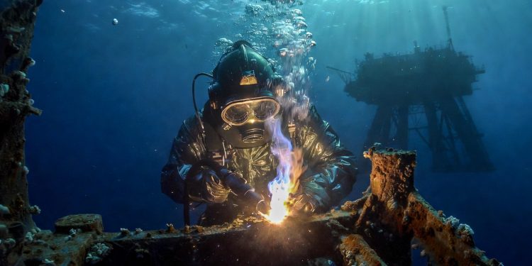 Soldador offshore especializado realiza reparos em estruturas de petróleo sob pressão marítima