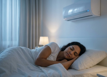 Mulher dormindo tranquilamente em quarto climatizado por um ar-condicionado moderno.