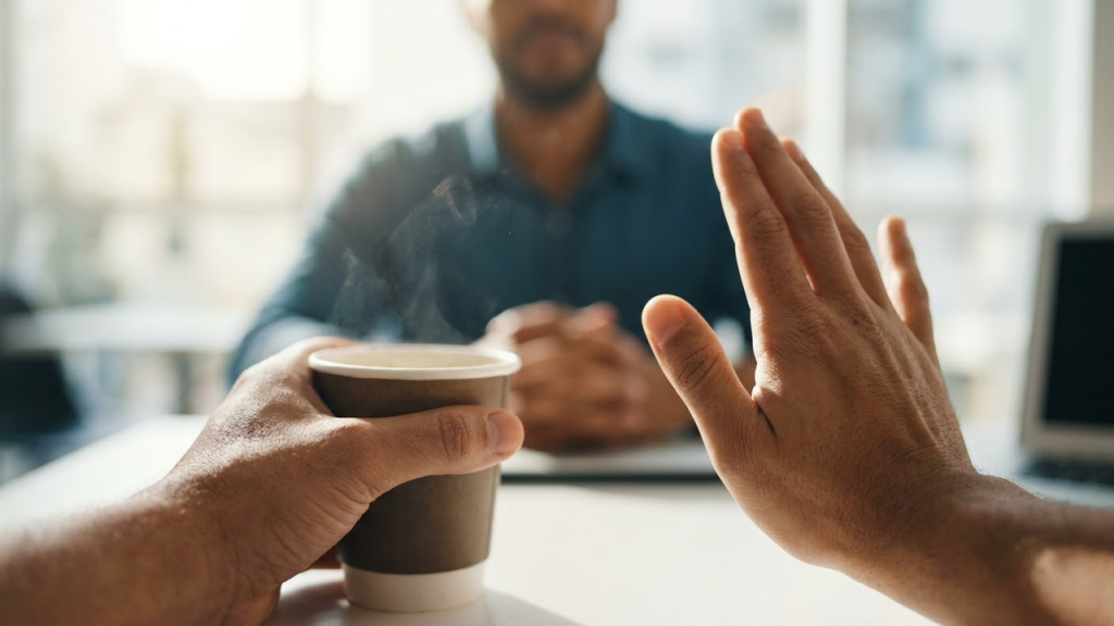 Visão em primeira pessoa de um gesto firme de limite durante uma conversa.