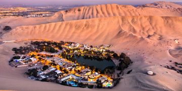 Com dezenas de palmeiras e dunas gigantes, o oásis de Huacachina surge como uma miragem surreal escondida no meio do deserto peruano