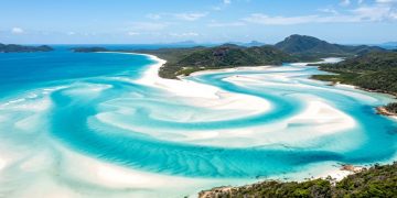 Apresentar Whitehaven Beach, destacando sua areia de sílica, beleza única e como visitá-la