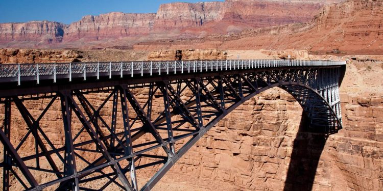 Com 254 metros de extensão sobre o Rio Colorado, a ponte histórica de 1929 surge como um marco da engenharia em meio ao deserto
