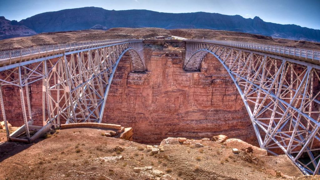 Com 254 metros de extensão sobre o Rio Colorado, a ponte histórica de 1929 surge como um marco da engenharia em meio ao deserto