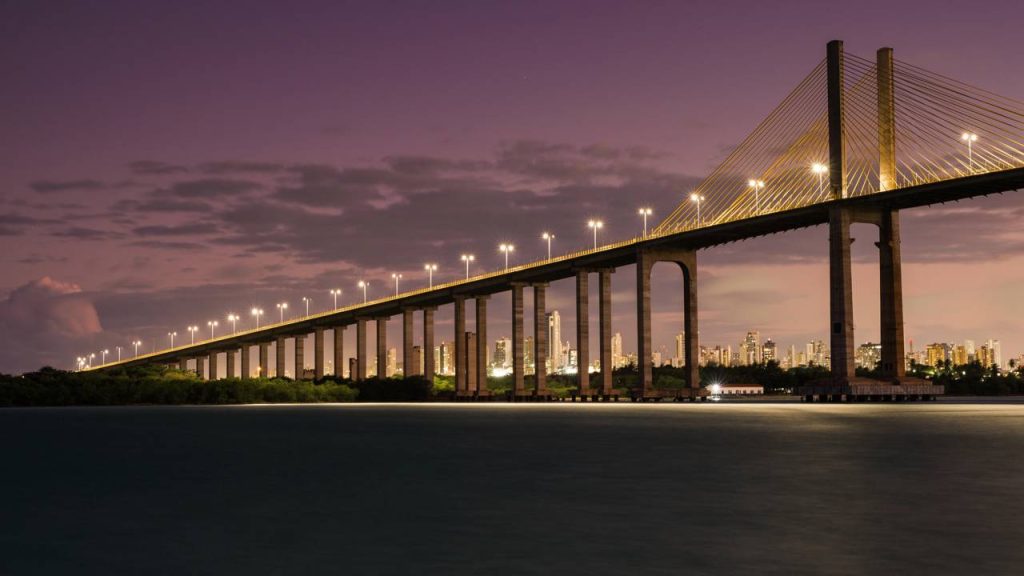 A monumental estrutura estaiada de 1,78 km que se eleva a 55 metros sobre o rio para ligar as praias da zona norte de Natal inaugurada em 2007