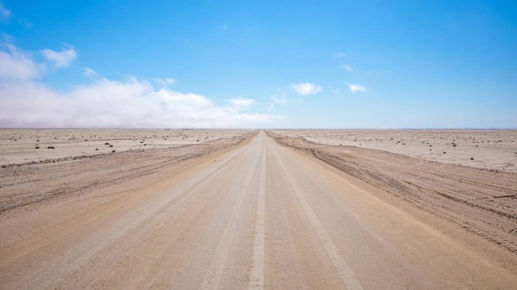 Com asfalto de sal e cercada por navios naufragados, a rota na Namíbia é um dos trajetos mais desafiadores do deserto do Namibe