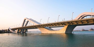 A estrutura de 842 metros com arcos que lembram dunas de areia ilumina a noite de Abu Dhabi como uma obra de arte