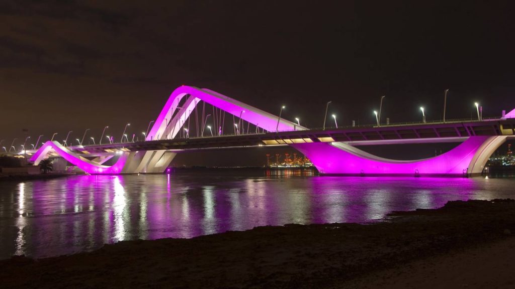 A estrutura de 842 metros com arcos que lembram dunas de areia ilumina a noite de Abu Dhabi como uma obra de arte