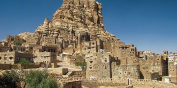 Erguida no topo de um penhasco íngreme, esta cidade fortificada de pedra resiste há séculos na aridez do Iêmen