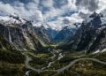 Com túneis escavados na rocha sólida e paredões com cachoeiras, a estrada desce as montanhas neozelandesas até o espetacular fiorde de Milford