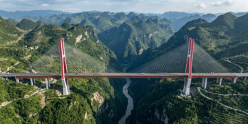Erigida a impressionantes 565 metros acima de um desfiladeiro rochoso na China, a gigantesca estrutura estaiada figura entre as pontes mais altas do mundo