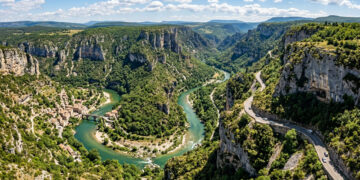 Serpenteando o fundo de um desfiladeiro monumental na França, a estrada cênica passa por túneis de pedra escavados diretamente na rocha