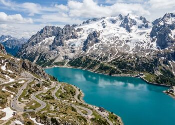 Com rampas íngremes de até dezoito por cento de inclinação nas Dolomitas, a estrada histórica margeia um lago glacial no topo da montanha italiana