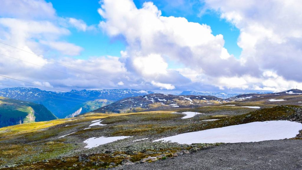 A rodovia na Noruega estende-se por 47 km de asfalto sinuoso; subindo a 1.306 metros de altitude, a rota revela corredores de neve no verão 