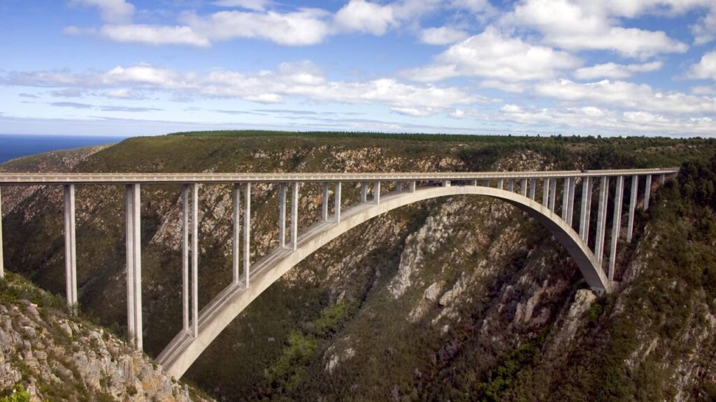 Suspensa a 216 metros sobre um desfiladeiro verde, a estrutura em arco de 1984 virou o ponto supremo para saltos de bungy jump