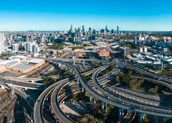 O movimentado trecho viário urbano cercado por colinas que abriga um dos eixos ferroviários mais movimentados e tecnológicos de Brisbane