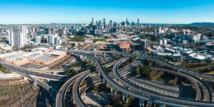 O movimentado trecho viário urbano cercado por colinas que abriga um dos eixos ferroviários mais movimentados e tecnológicos de Brisbane