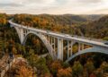 Erguida na cênica rota do Tennessee, com um inovador design de arco duplo sem pilares visíveis, a premiada ponte de concreto destaca-se na mata