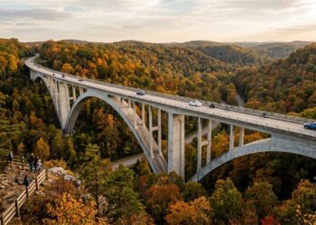 Erguida na cênica rota do Tennessee, com um inovador design de arco duplo sem pilares visíveis, a premiada ponte de concreto destaca-se na mata
