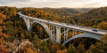 Erguida na cênica rota do Tennessee, com um inovador design de arco duplo sem pilares visíveis, a premiada ponte de concreto destaca-se na mata