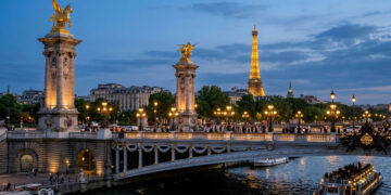 Datada de 1900, a ponte metálica de 107 metros exibe estátuas douradas e lustres clássicos cruzando as águas do rio Sena em Paris