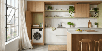 Esta lavanderia escondida atrás de portas ripadas parece armário de corredor, mas guarda tanque, máquina e produtos sem roubar a área social do apartamento