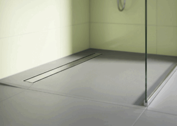 Este corte milimétrico no canto do box parece apenas detalhe estético de hotel, mas resolve o escoamento do chuveiro de alta vazão sem precisar cortar o piso em quatro águas