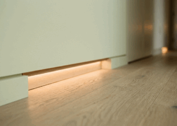 Não é automação cara, nem capricho de hotel: os balizadores em fita de LED embutidos no rodapé iluminam o caminho até o banheiro sem despertar o cérebro no meio da madrugada