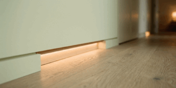Não é automação cara, nem capricho de hotel: os balizadores em fita de LED embutidos no rodapé iluminam o caminho até o banheiro sem despertar o cérebro no meio da madrugada
