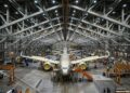 Um gigantesco hangar abriga aviões tão longos quanto prédios altos sob treliças que vencem 91 metros sem pilares centrais