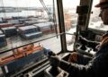 Operador de RTG trabalha a dezenas de metros do chão movimentando contêineres que pesam toneladas