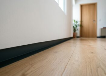 Sem rodapé aparecendo na parede, um recuo de poucos centímetros cria uma linha de sombra junto ao chão e muda completamente o acabamento dos ambientes