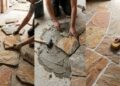 Azulejista especializado em pedra natural trabalha com peças que não chegam perfeitamente iguais e cada parede exige uma paginação diferente