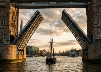 Construída sobre o rio sem interromper a navegação, a Tower Bridge ergue seus dois tabuleiros centrais para a passagem de grandes embarcações