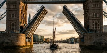 Construída sobre o rio sem interromper a navegação, a Tower Bridge ergue seus dois tabuleiros centrais para a passagem de grandes embarcações