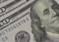 Painel eletrônico exibindo cotação do dólar em ambiente de bolsa de valores.